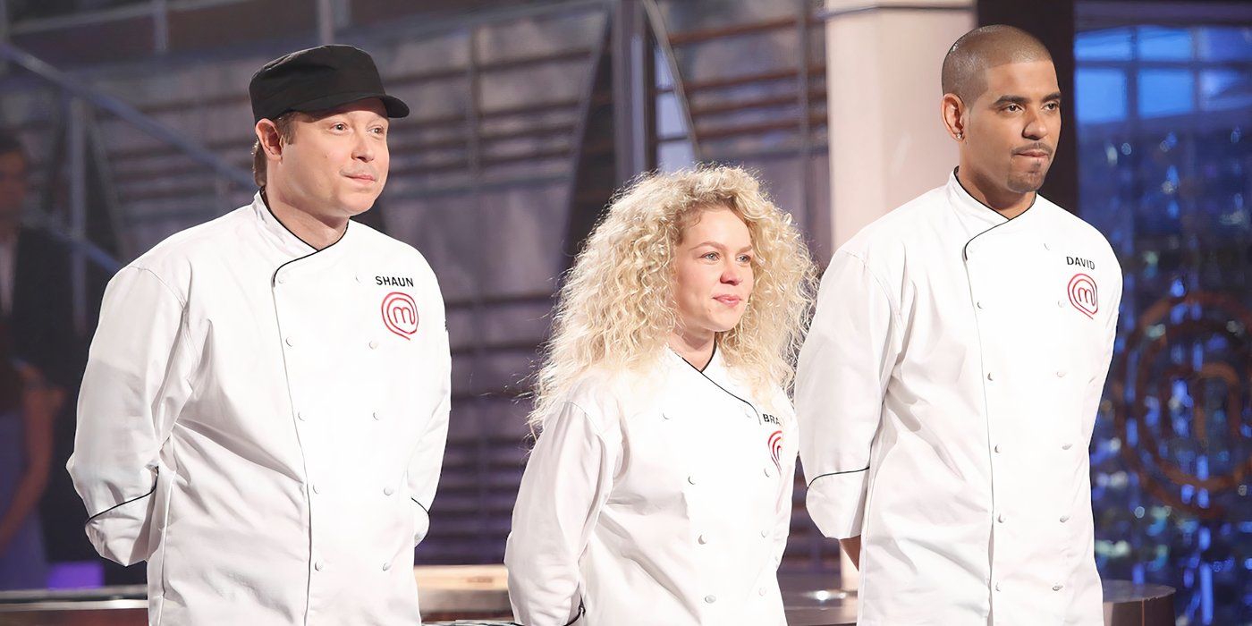 Three contestants from Masterchef standing in a row with white chef jackets, hands behind their back.