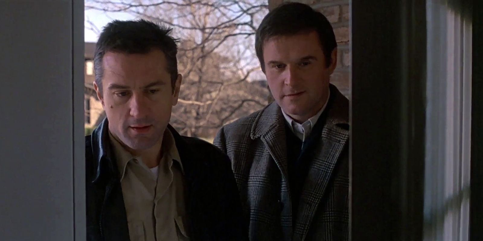 Robert De Niro and Charles Grodin stand in a doorway in Midnight Run