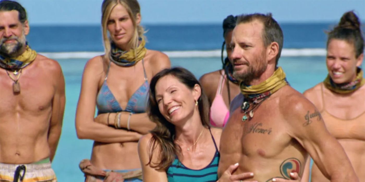 Monica embracing her husband Brad on Survivor as other players look on. 