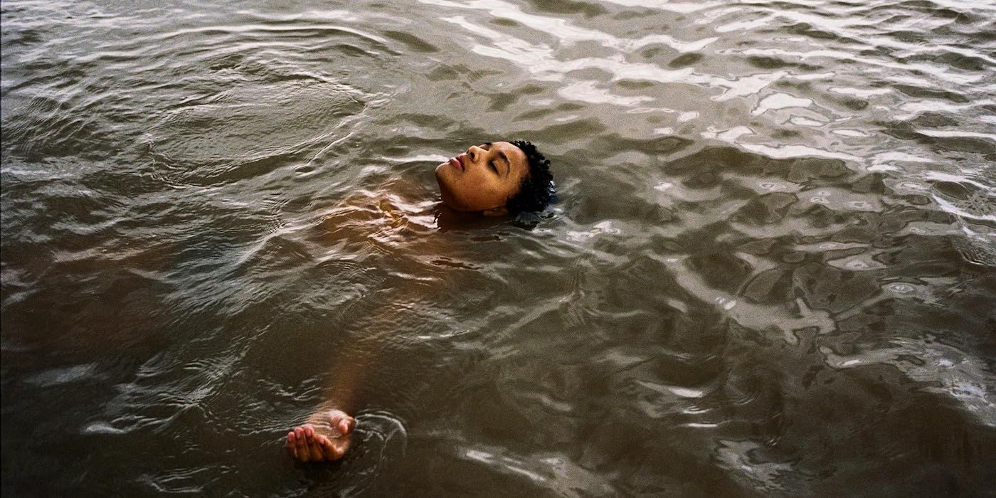 Nykiya Adams as Bailey laying back in the water in Bird. 