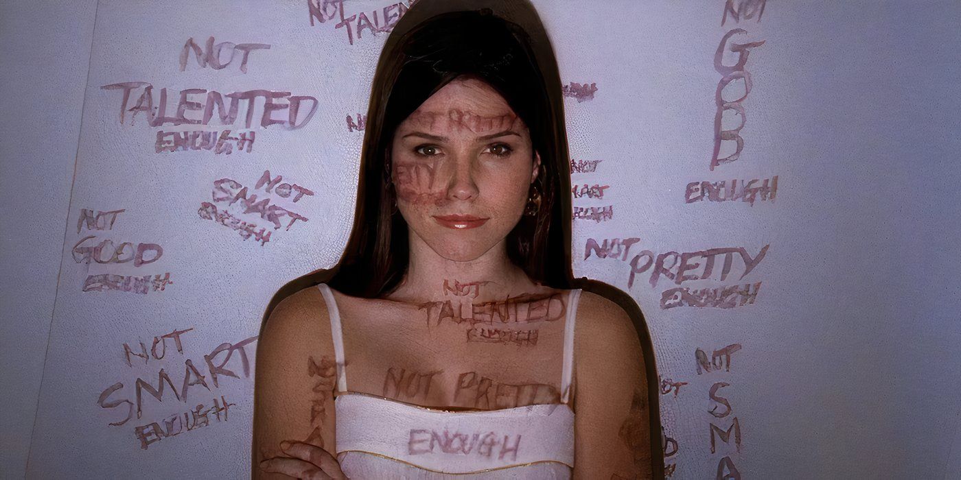 Sophia Bush with her arms crossed in front of a white wall with words projected on her.