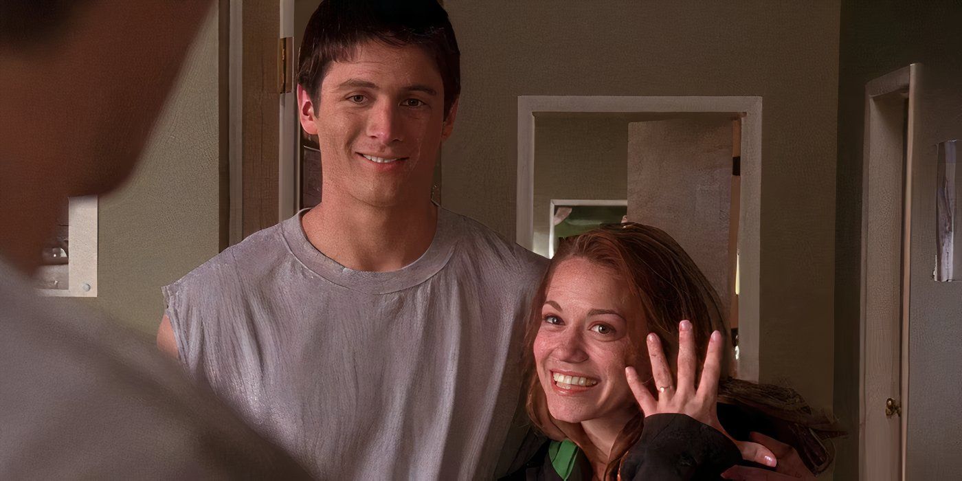 Bethany Joy Lenz with her hand up showing a ring while James Lafferty puts his arm around her.