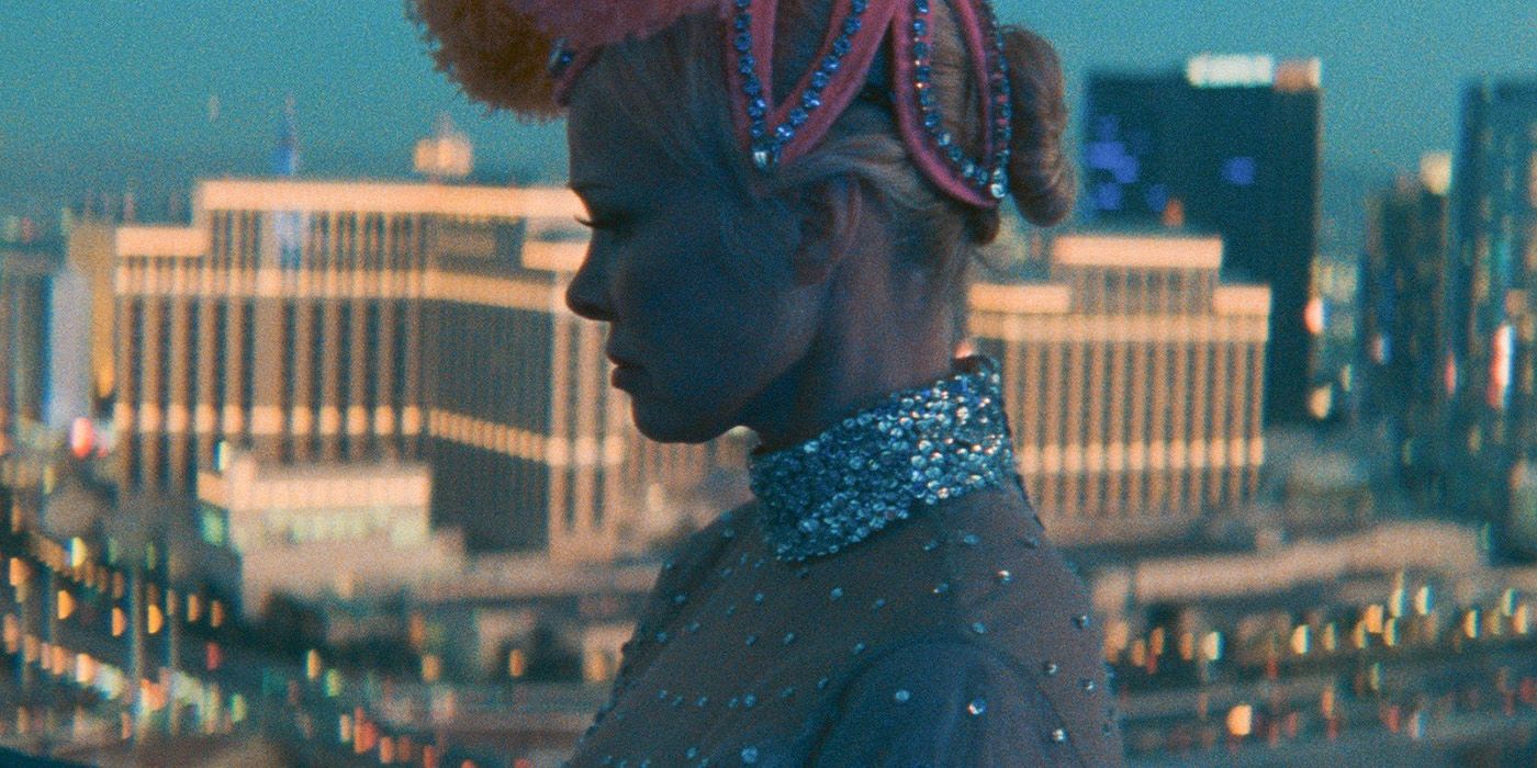 Pamela-Anderson in a showgirl costume in front of a blurry vegas background in The Last Showgirl