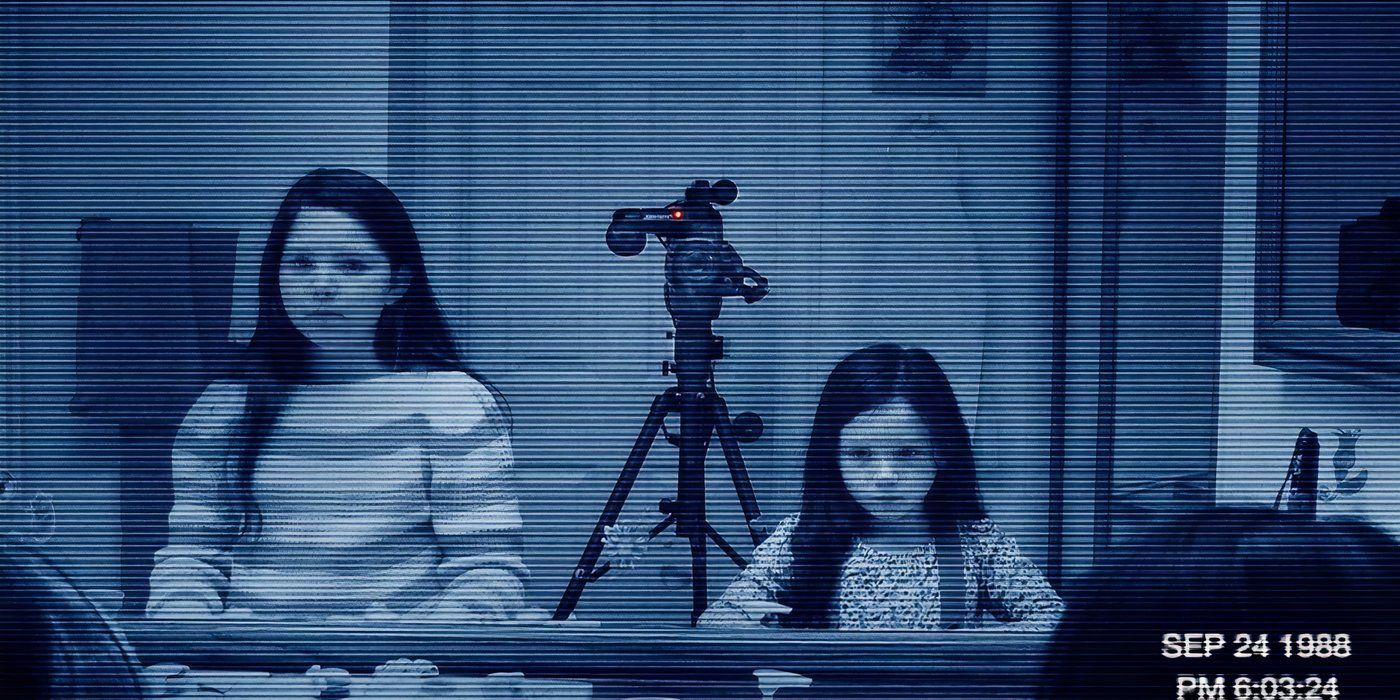 Grainy footage of two little girls staring into a mirror with a camera mounted on a tripod between them