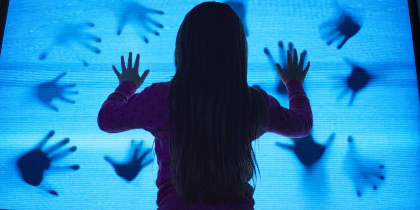 Madison Bowen (Kennedi Clements) stands in front of a TV with hands on the screen in 'Poltergeist' (2015)