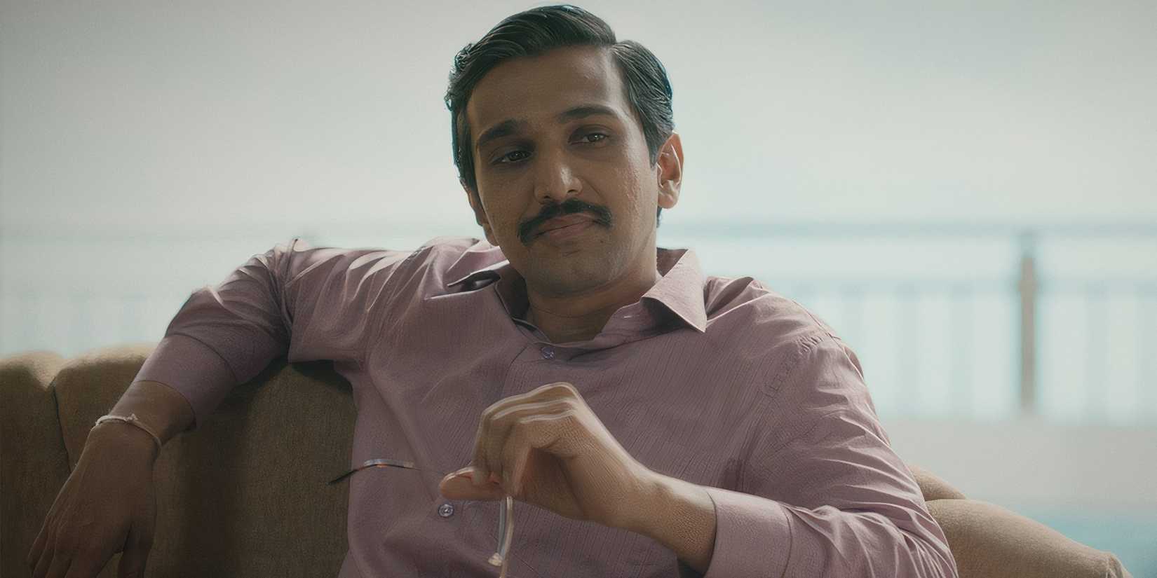 Pratik Gandhi holding his glasses in 'Scam 1992 - The Harshad Mehta Story'
