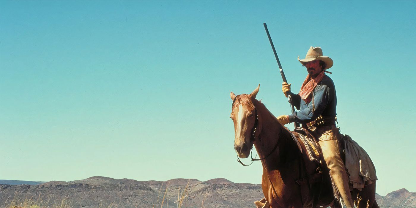 Tom Selleck as Matthew Quigley riding a horse, holding a gun in Quigley Down Under.