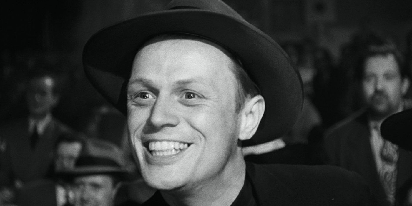 Richard Widmark como Tommy Udo, riendo a carcajadas entre la multitud en El beso de la muerte (1947)