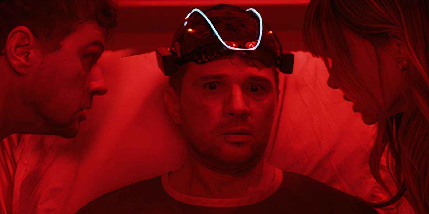 Ryan Phillippe laying in a hospital bed with a head gear and scared facial expression as two people look at him.