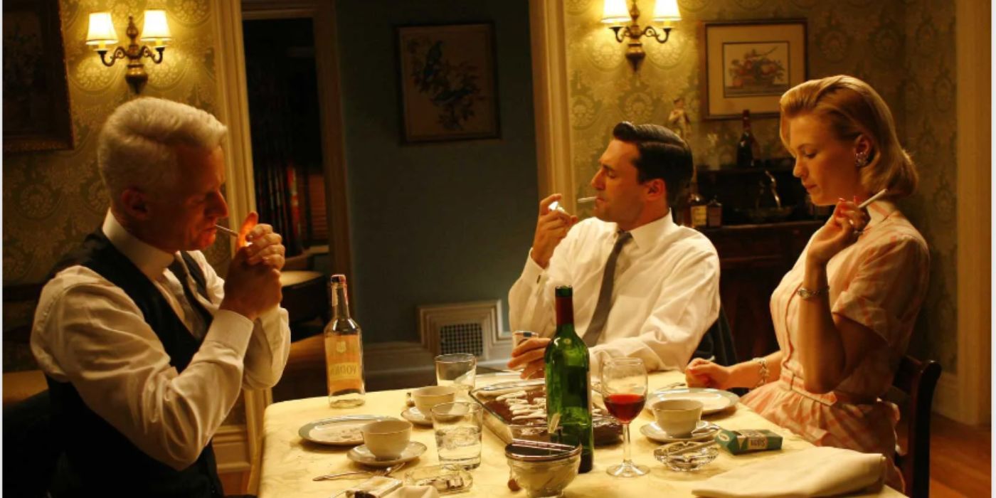 John Flaherty, John Hamm, and January Jones as Roger, Don, and Betty smoking cigarettes at the dinner table in 'Mad Men'