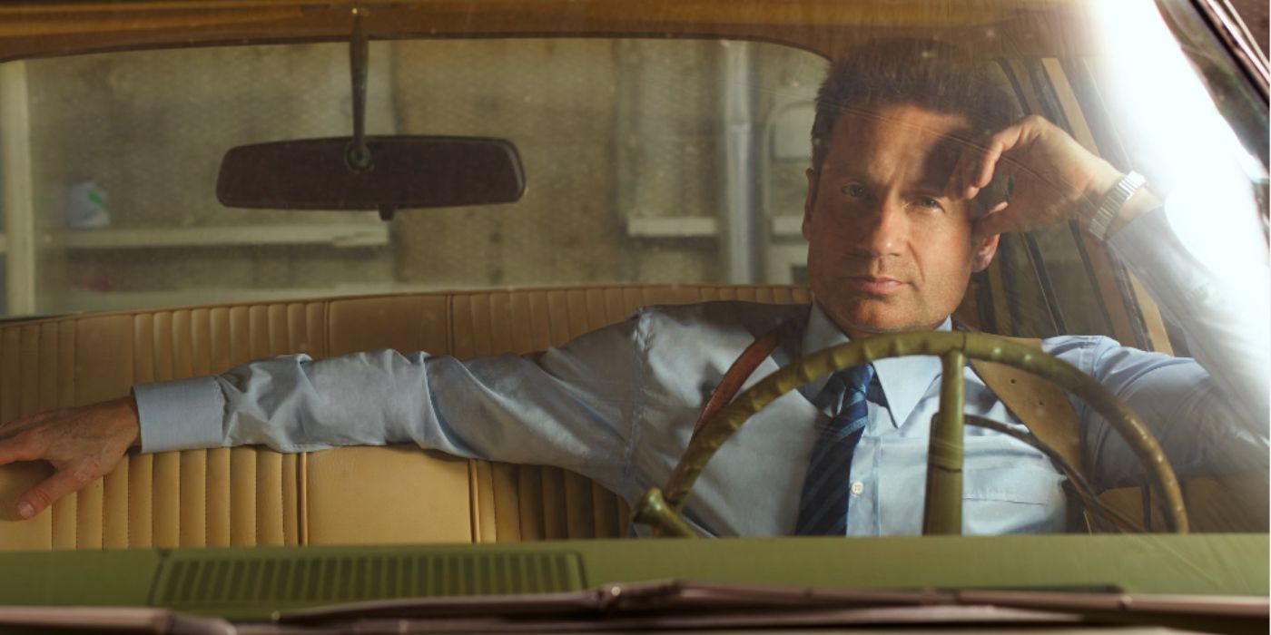 David Duchovny as Sam Hodiak sitting in car in blue shirt in 'Aquarius'