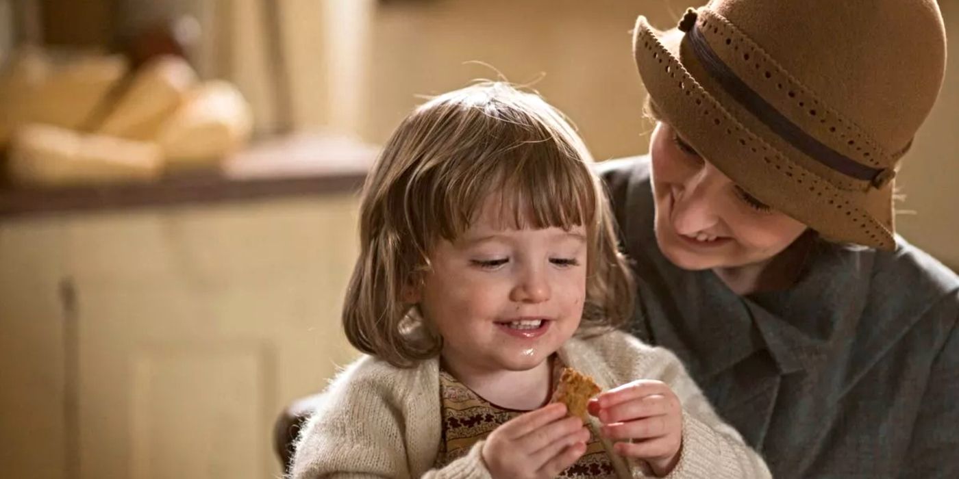 Eva/Karina Samms as Marigold Gregson, being held by Edith Crawley (Laura Carmichael) while she eats a cookie on Downton Abbey