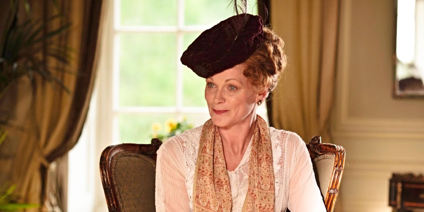 Samantha Bond as Rosamund Painswick, sitting and smiling on Downton Abbey