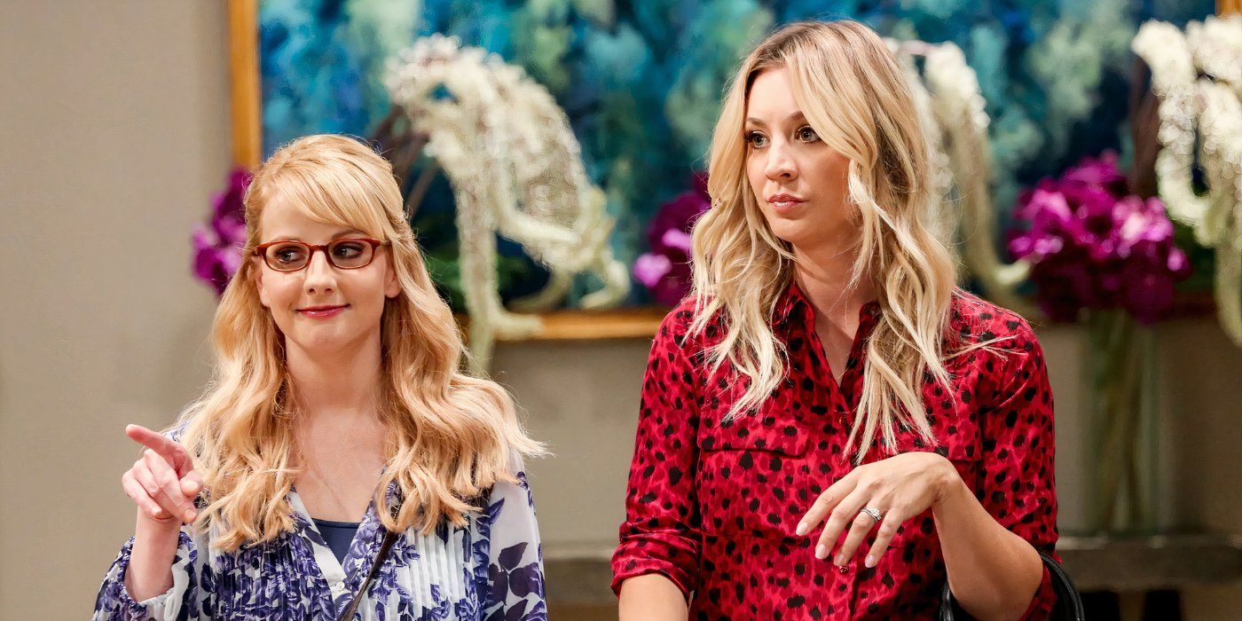 Bernadette (Melissa Rauch) and Penny (Kaley Cuoco) standing in a lobby with flowers behind them, looking unimpressed on The Big Bang Theory