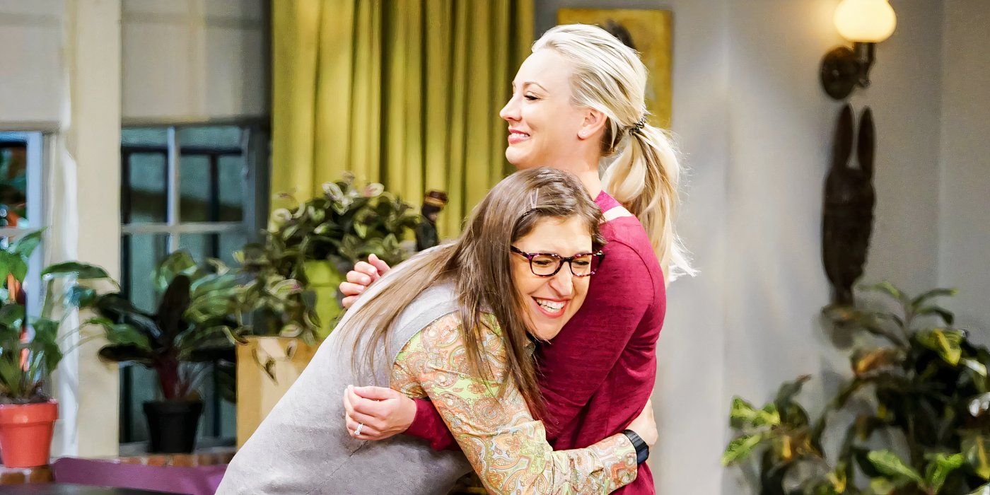 Amy (Mayim Bialik) aggressively hugging Penny (Kaley Cuoco) while they both smile on The Big Bang Theory