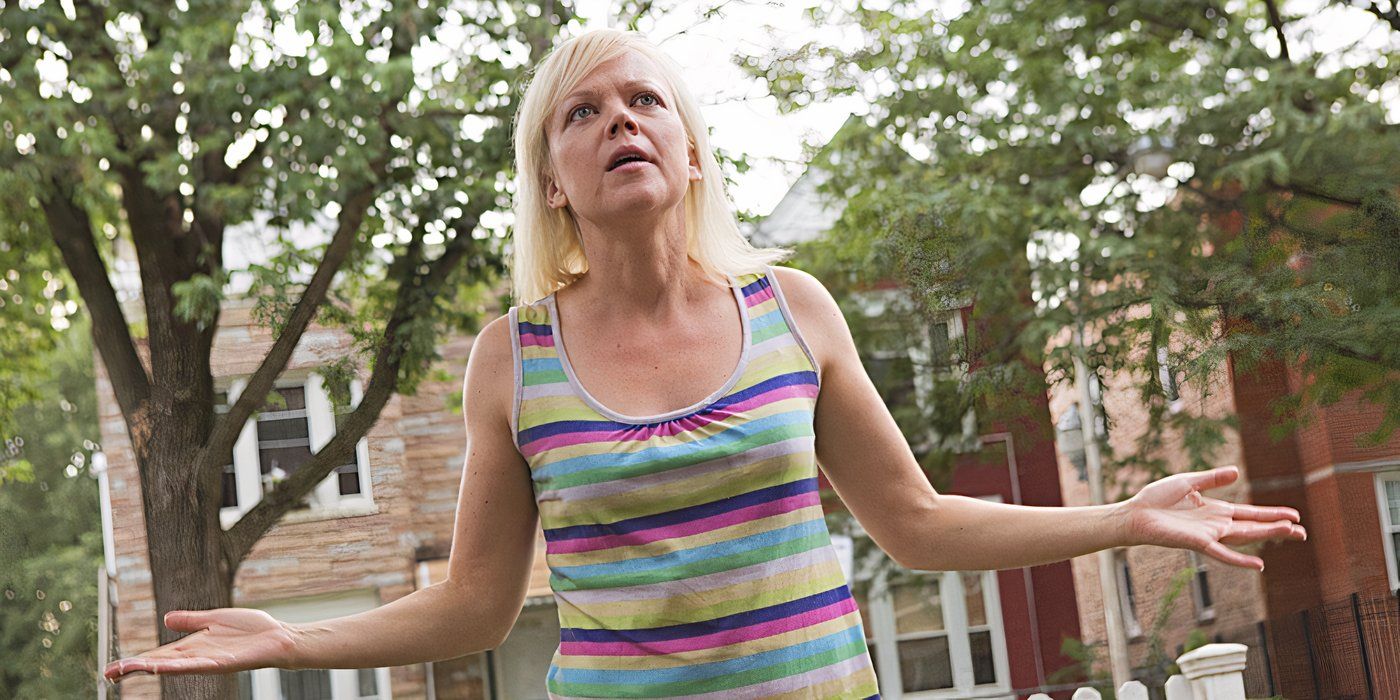 Emily Bergl as Sammi Slott, standing outside in a striped tank top with her arms held out to her sides on Shameless