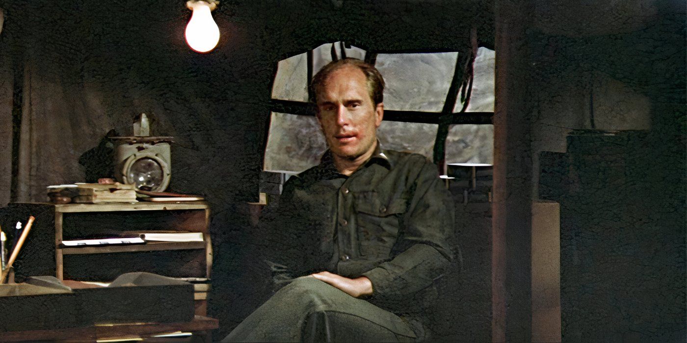 Robert Duvall as Major Frank Burns, sitting in a tent looking afraid in 1970's M*A*S*H