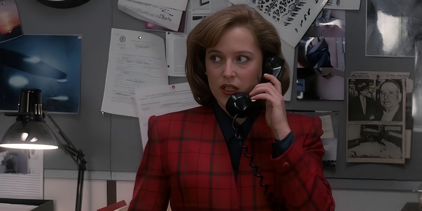 Gillian Anderson makes a call from the basement office as Scully wearing a red suit in The X-Files.