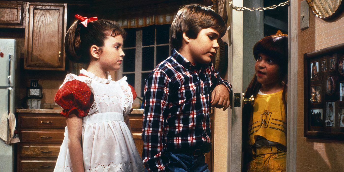 Vicki the robot, a young boy, and a nosy neighbour trying to get into the house in Small Wonder.