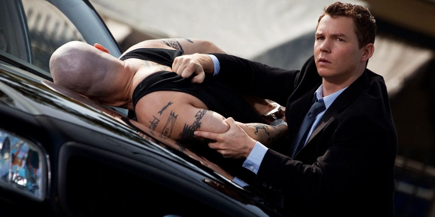 Shawn Hatosy holds a tattooed, handcuffed man leaning over the hood of car in a scene from 'Southland.'