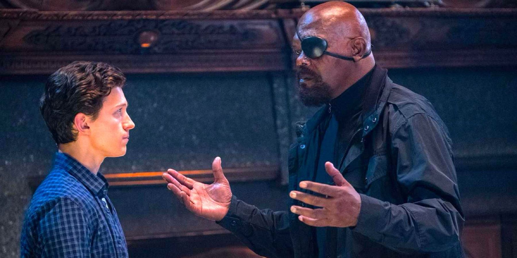 Peter Parker (played by actor Tom Holland) and Nick Fury (played by actor Samuel L. Jackson), share a tense conversation in front of a fireplace in Spider-Man: Far From Home.