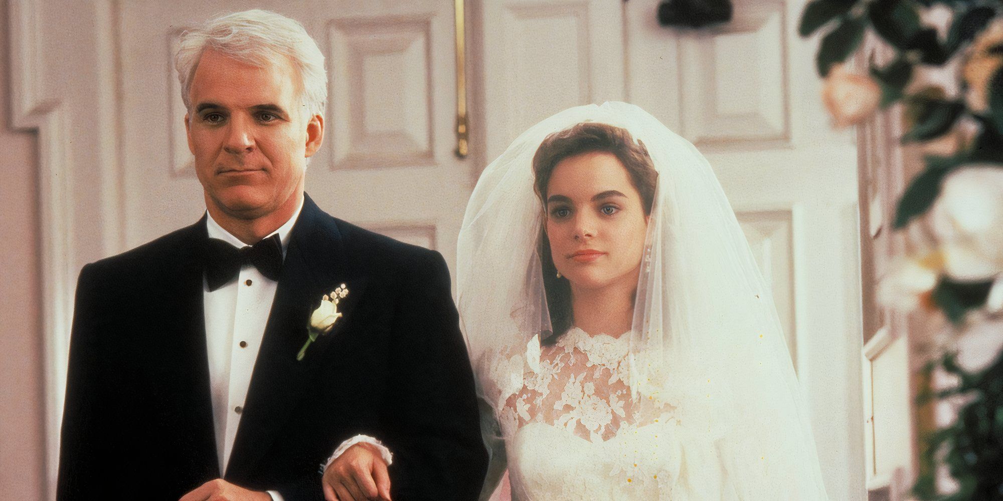 Steve Martin as George Banks and Kimberly Williams-Paisley as Annie Banks in Father of the Bride walking together down the aisle at her wedding.