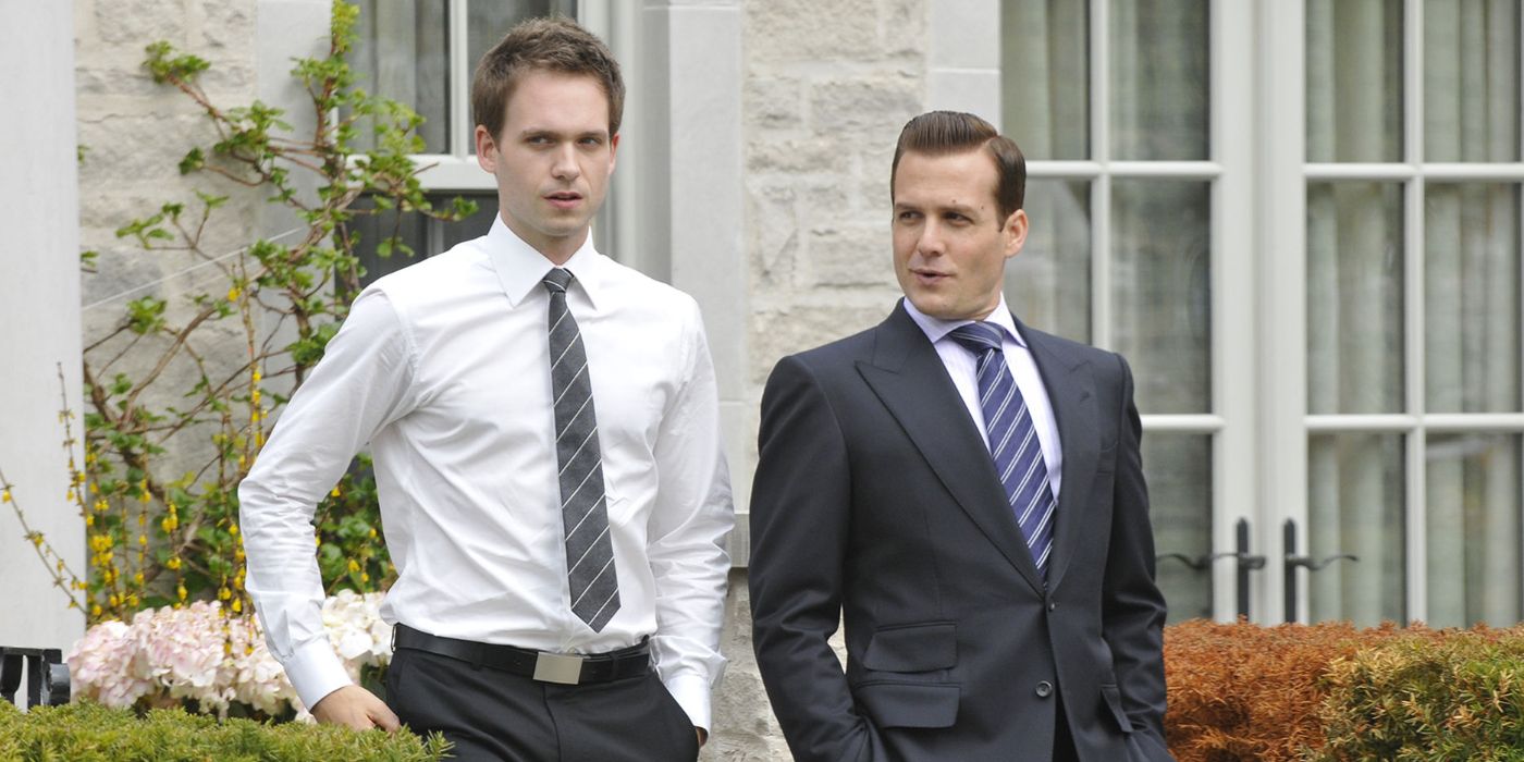 Mike Ross (Patrick J. Adams) and Harvey Specter (Gabriel Macht) walk in a garden courtyard in Suits.
