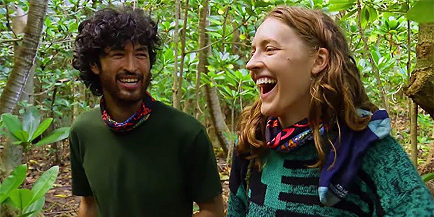 Matt and Frannie walking together in the forest on Survivor, both smiling and laughing.