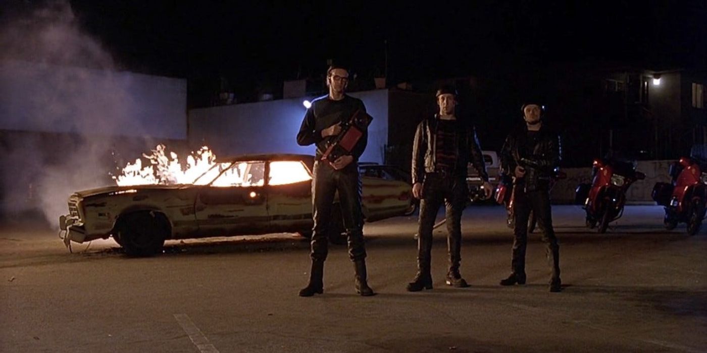 The Nihilists stand in a parking lot before a burning car in 'The Big Lebowski' (1998).