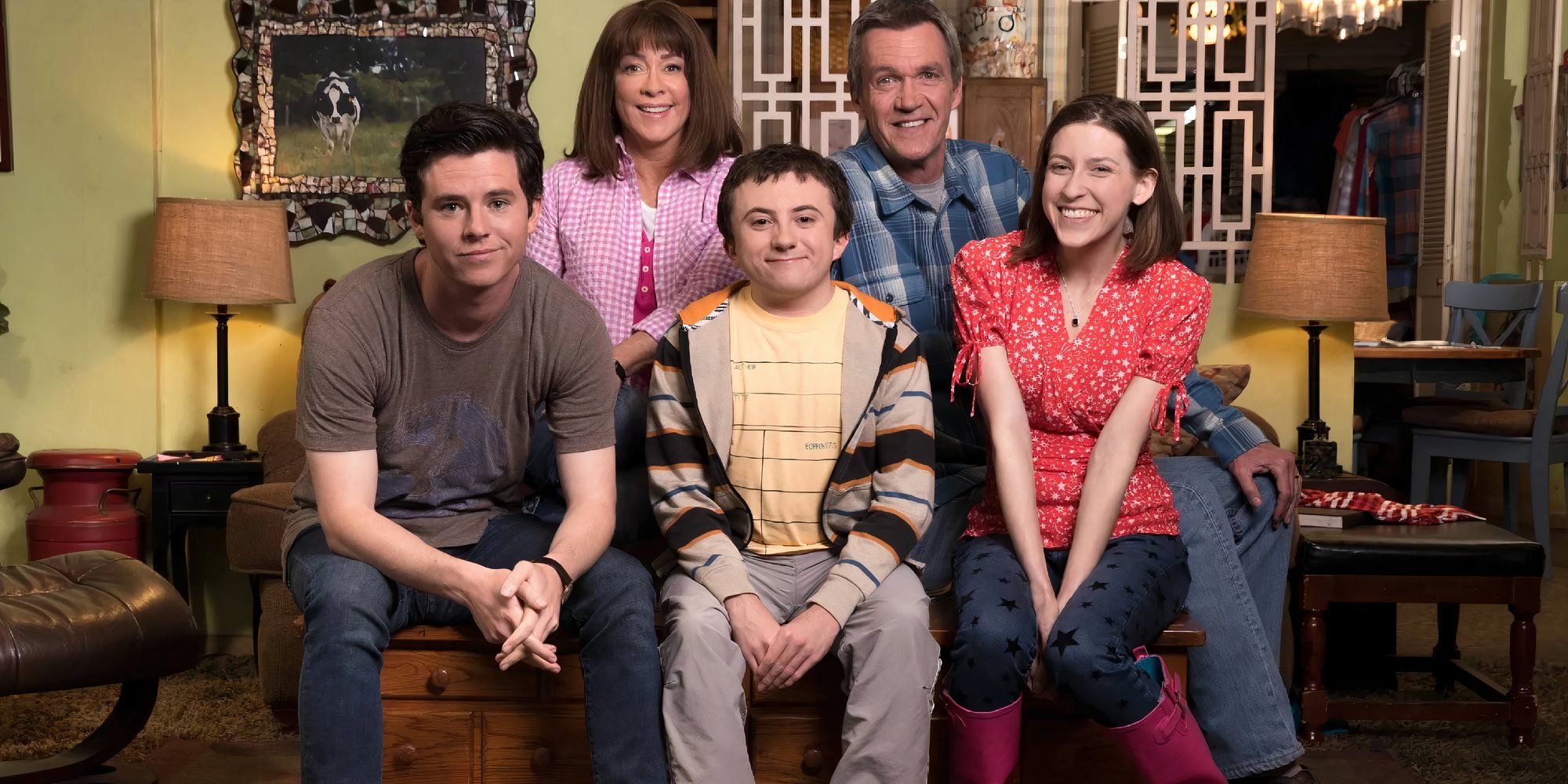 The cast of the middle sitting next to each other on a sofa.