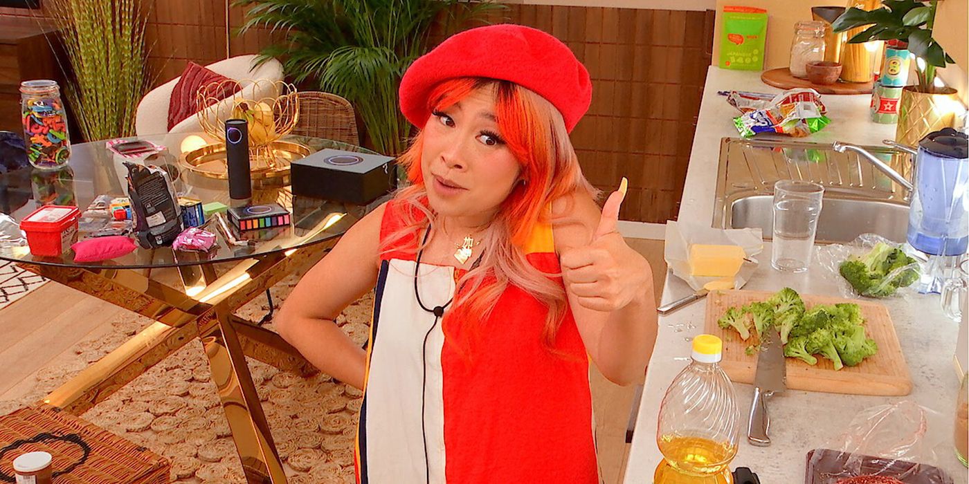 Yu Ling Wu from The Circle wearing a bright orange-ish red outfit, giving a thumbs up to the camera.