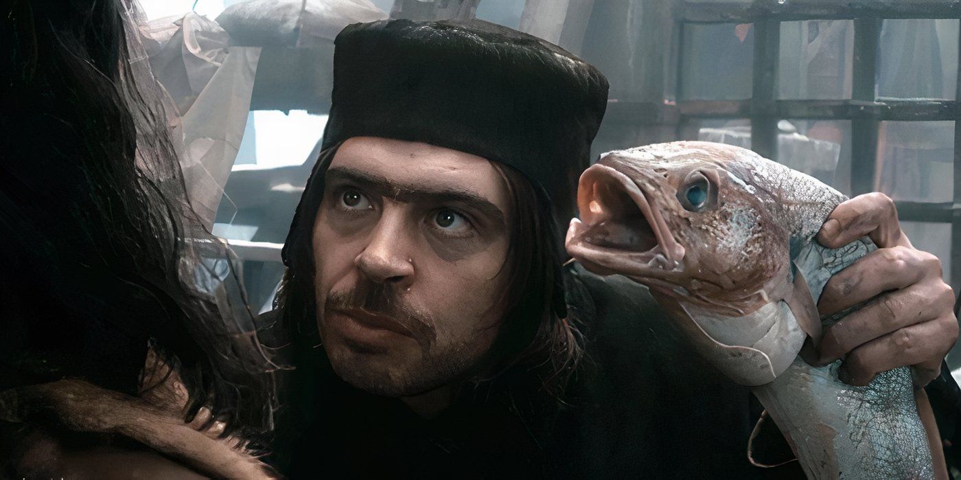 Alfrid Lickspittle holds up a dead fish to Bard in The Hobbit: The Desolation of Smaug