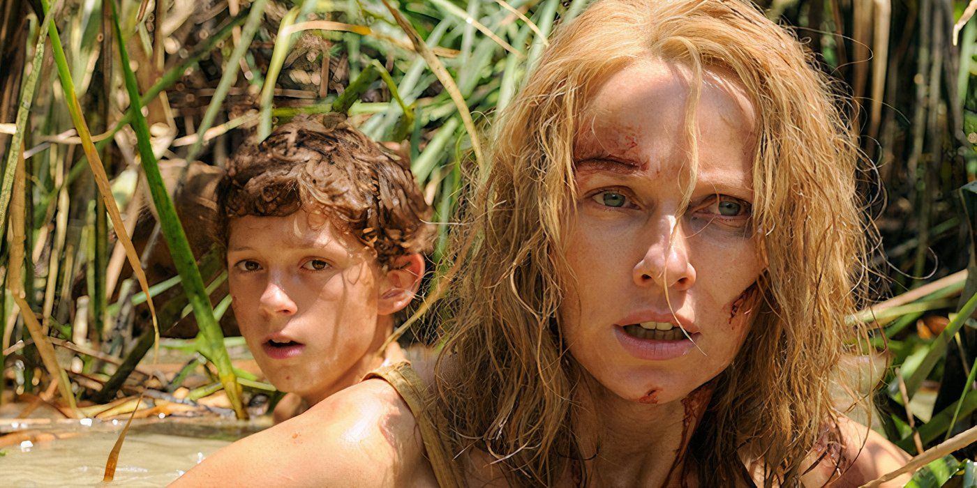 Naomi Watts and Tom Holland as Maria and Lucas Bennett, injured and wading through muddy water after the tsunami in The Impossible
