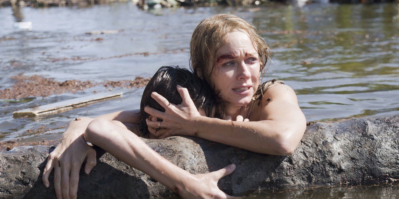 Maria Bennett (Naomi Watts) clinging to a floating tree while holding tightly to Lucas (Tom Holland) in The Impossible