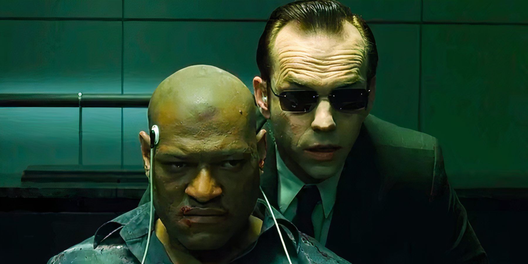 Agent Smith stands menacingly over Morpheus who is being held captive in The Matrix.