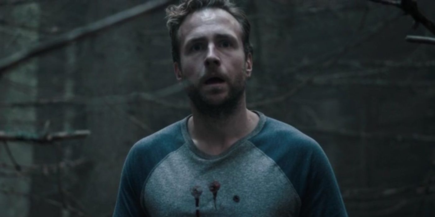 Rafe Spall as Luke looking frightened in the woods in 2017's The Ritual