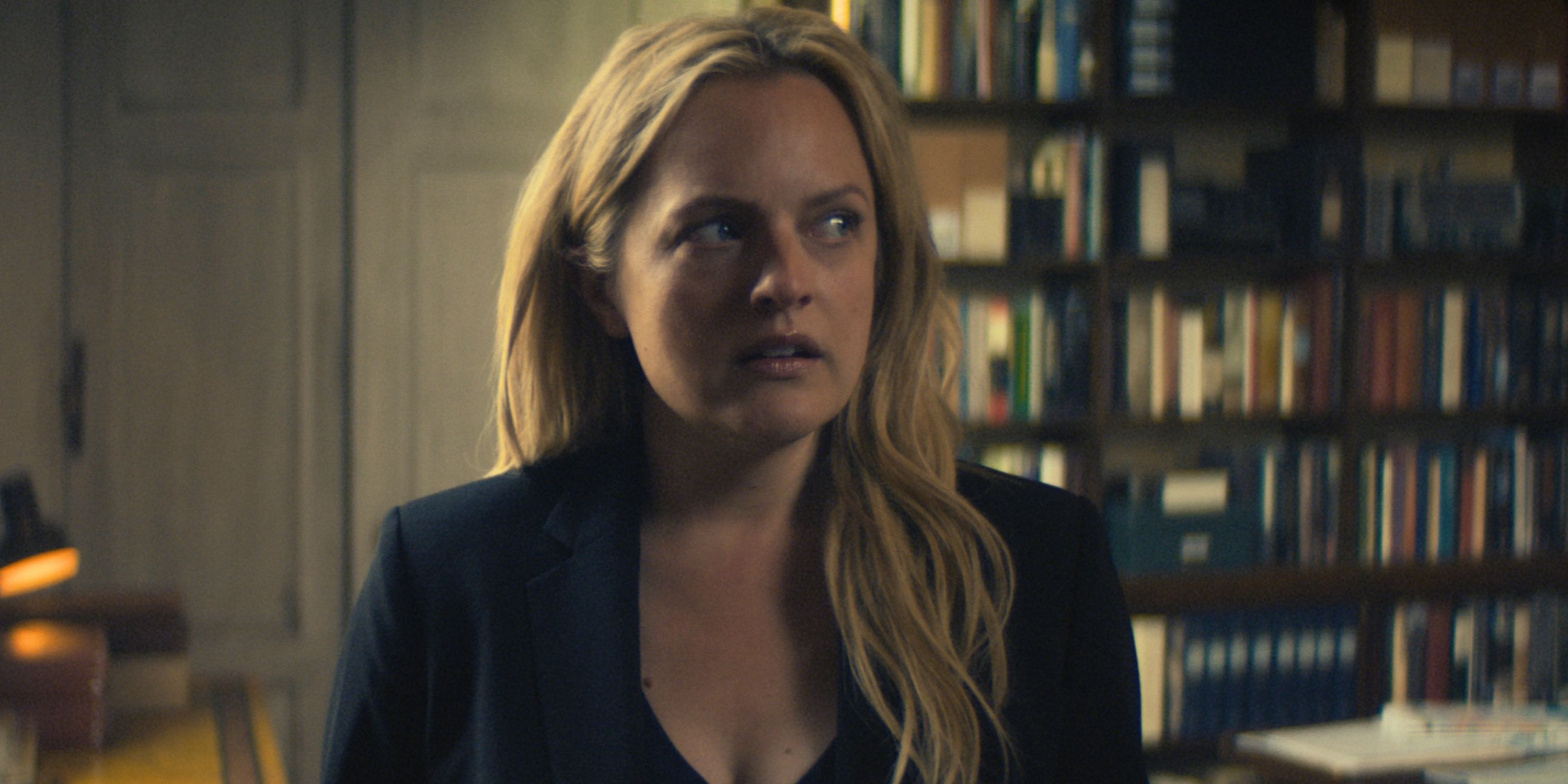 Elisabeth Moss as Imogen Salter looking off to the left in a black v-neck shirt and jacket in The Veil