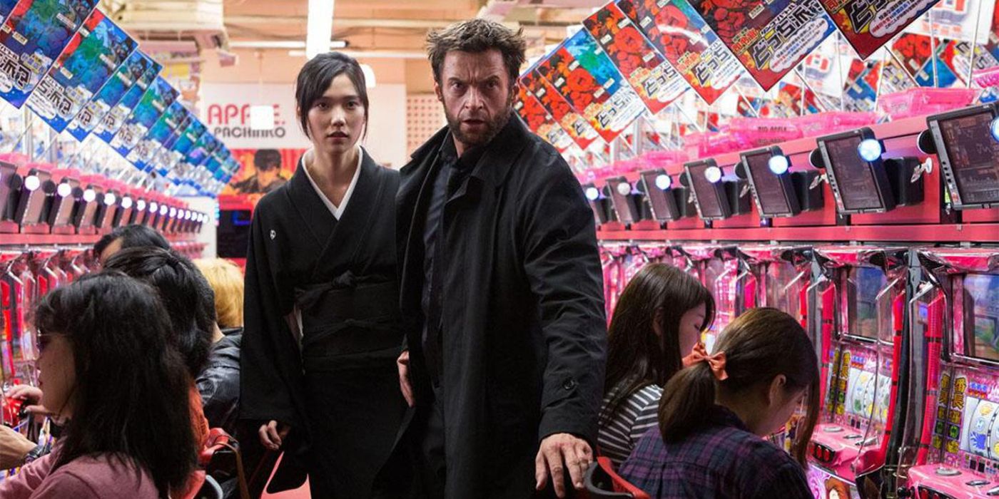Mariko Yashida (Tao Okamoto) standing behind Wolverine (Hugh Jackman) in a gaming arcade arena in The Wolverine