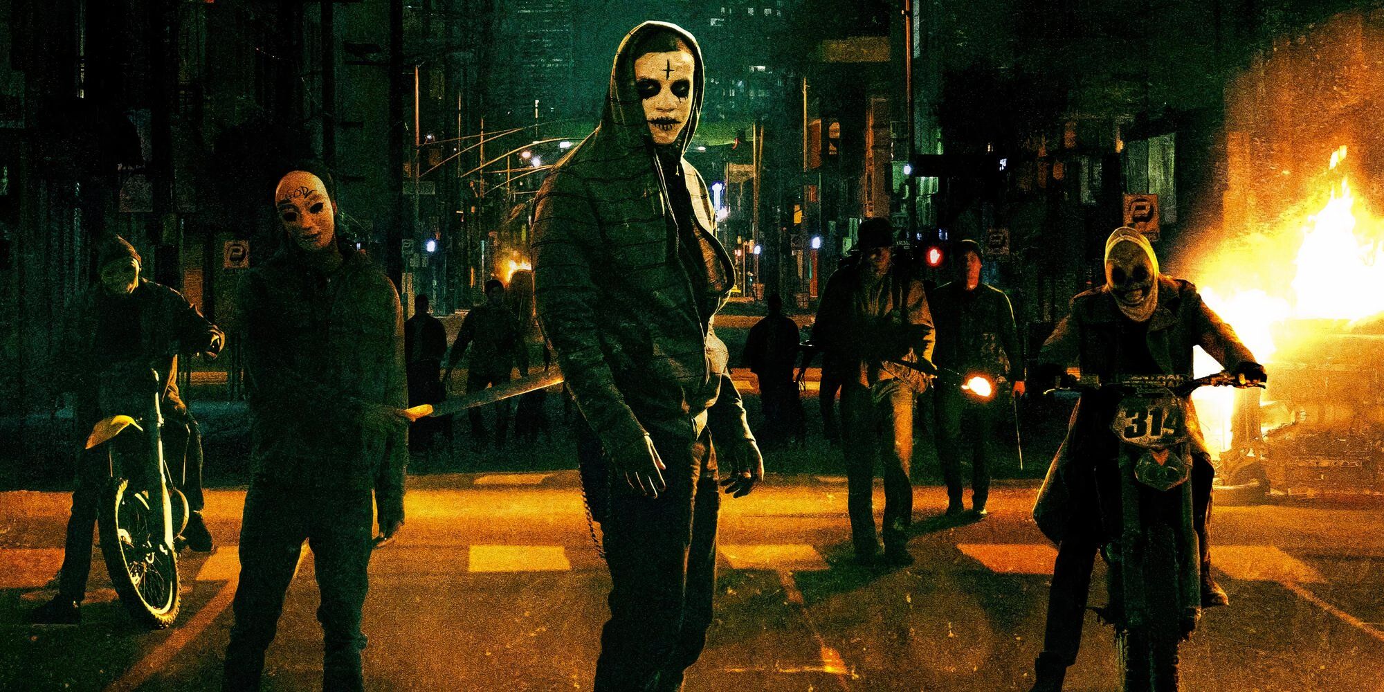 Un groupe de personnes portant du maquillage et des masques élaborés au milieu de la rue dans « The Purge : Anarchy »