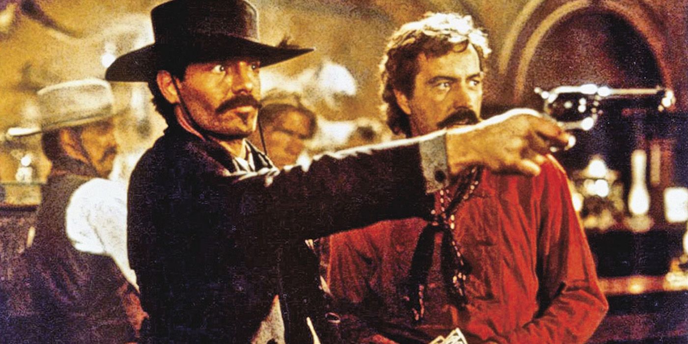 Johnny Ringo (Michael Biehn) tire son pistolet avec Curly Bill (Powers Booth) en arrière-plan en «Tombstone».