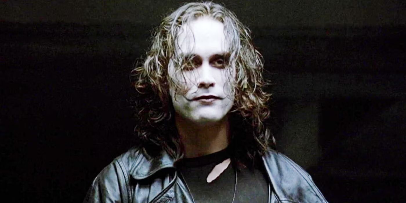 Brandon Lee as Eric Draven in the black costume and black coat with the white face makeup in The Crow