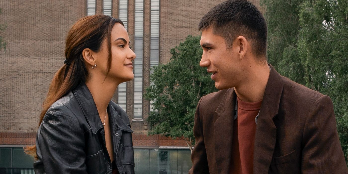 Camila Mendes and Archie Renaux look at each other in front of a brick building in Upgraded.