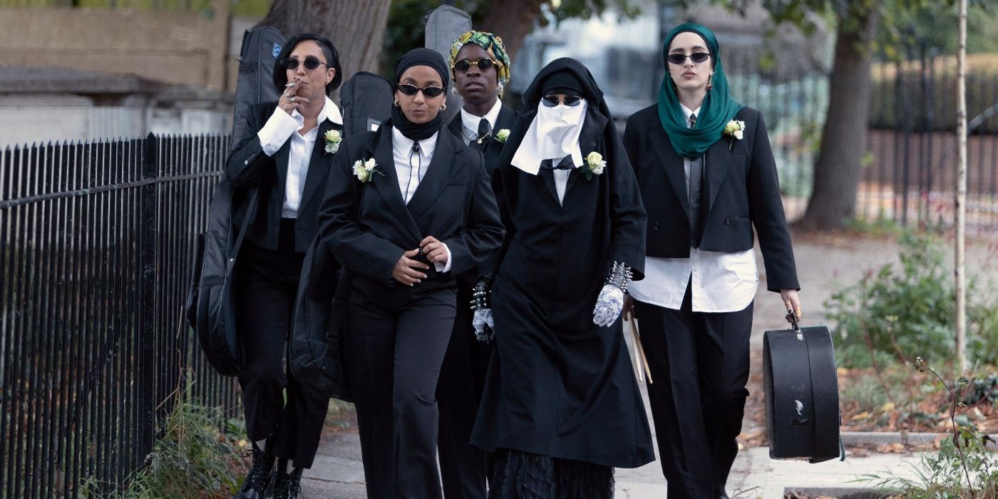 O elenco de We Are Lady Parts Season 2 andando por uma rua em desgaste formal preto
