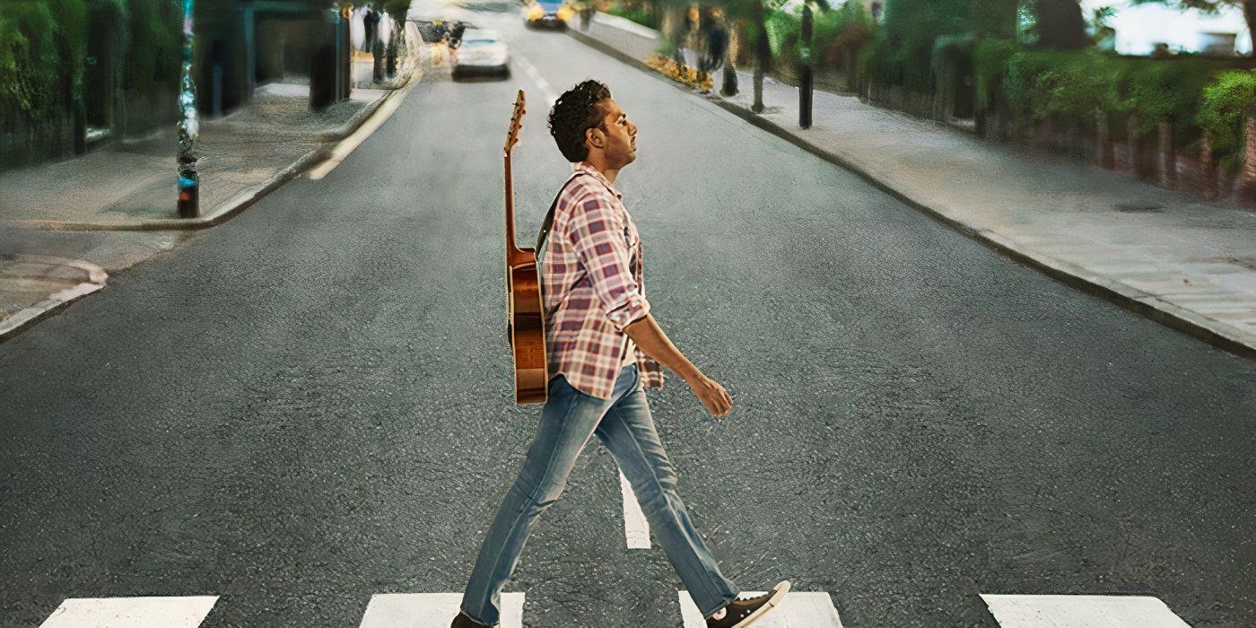 Jack (Himesh Patel) walks across a crosswalk with a guitar on his back, mimicking the "Abbey Road' album cover by the Beatles 