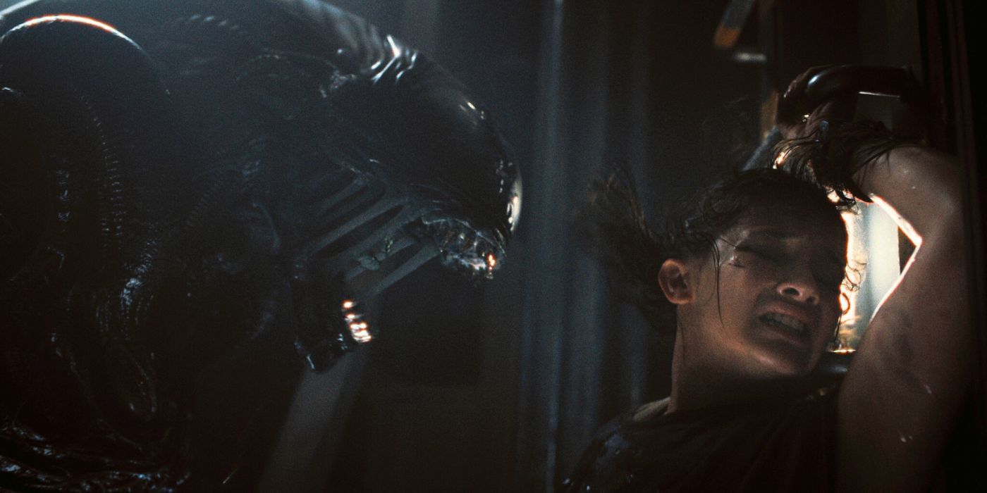 A Xenomorph screaming in the face of a woman in 'Alien: Romulus.'