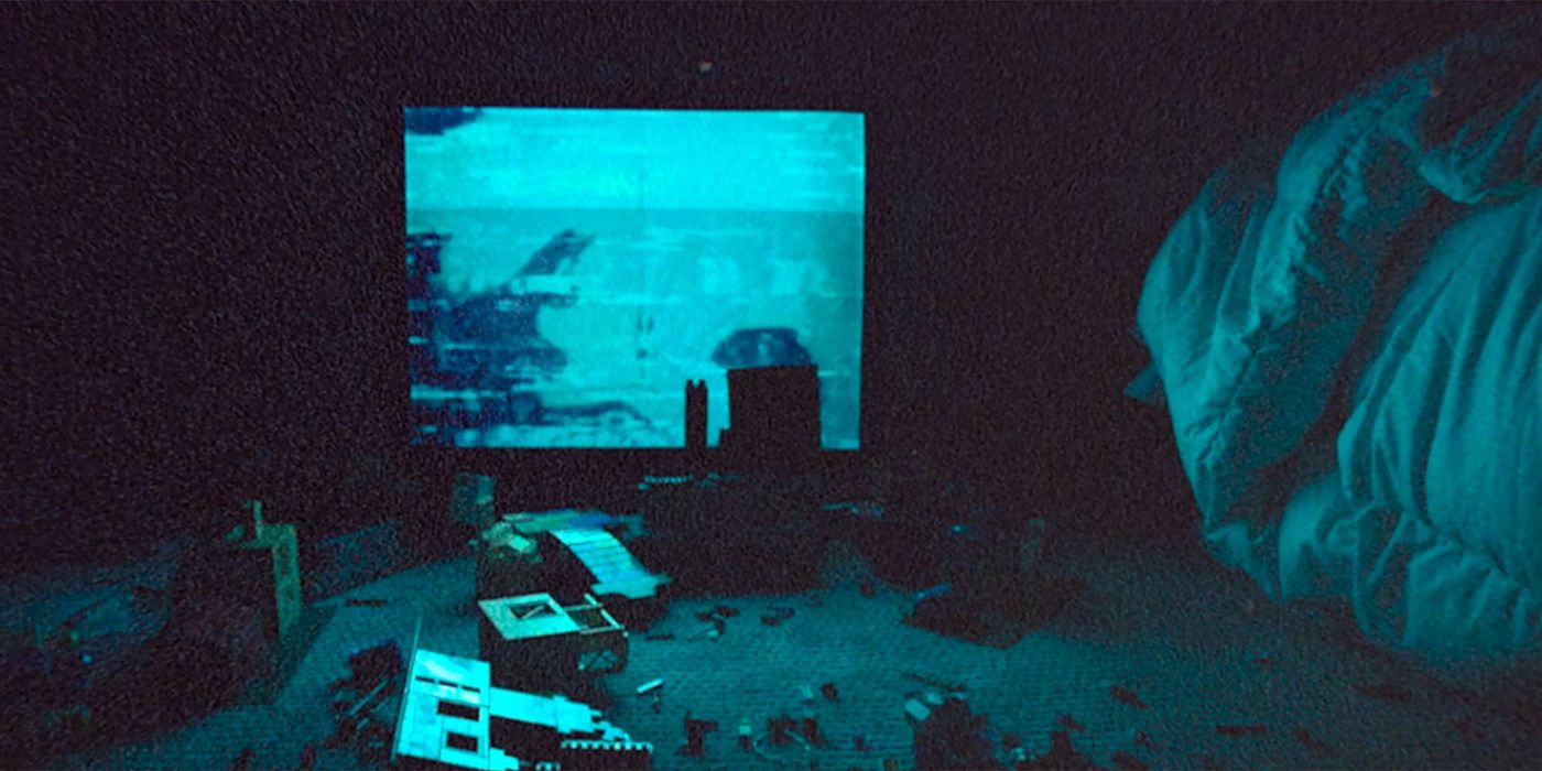 A tv casts a blue glow over a room in a scene from Skinamarink. 