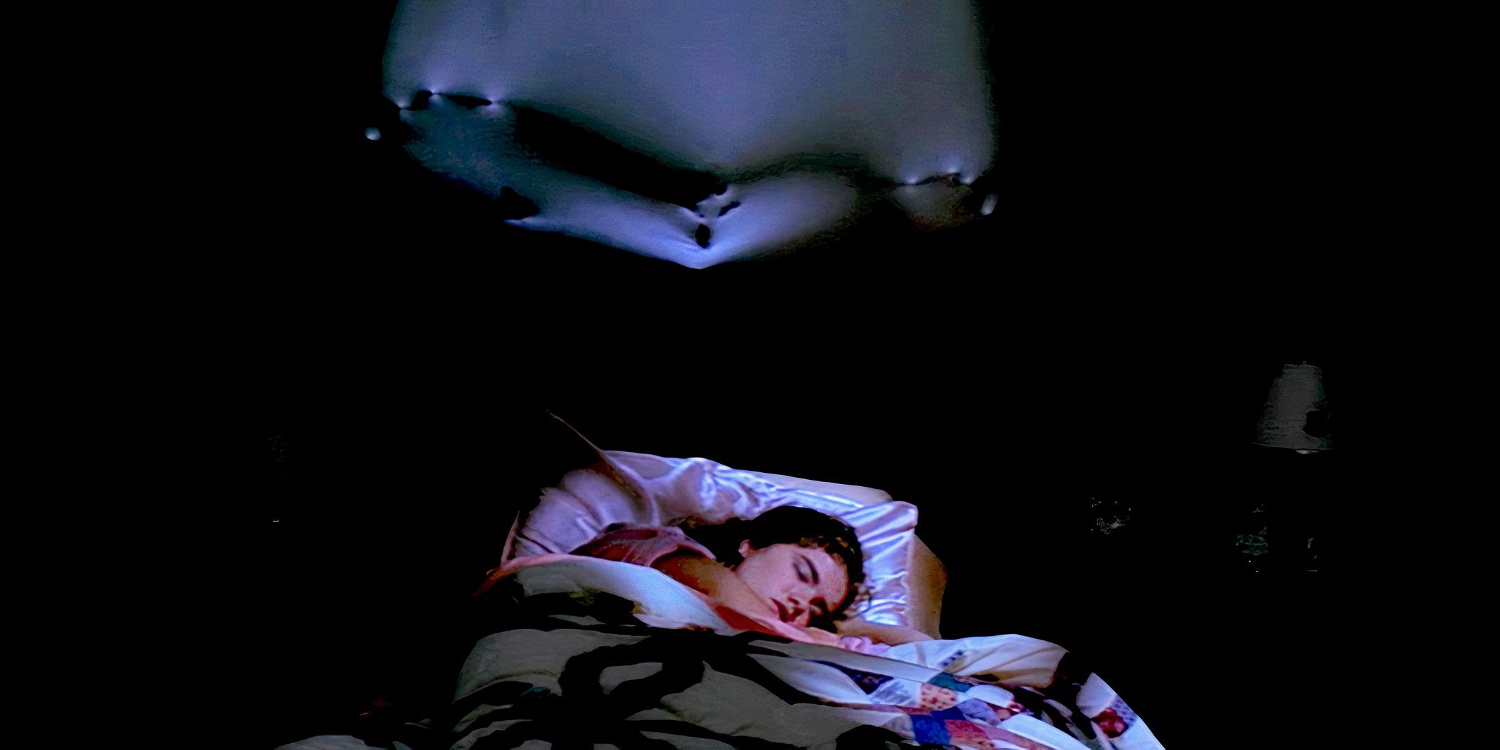 Nancy Thompson, played by actor Heather Langenkamp, sleeps as Freddy Krueger's claws appear in the wall behind her in 'A Nightmare on Elm Street'.