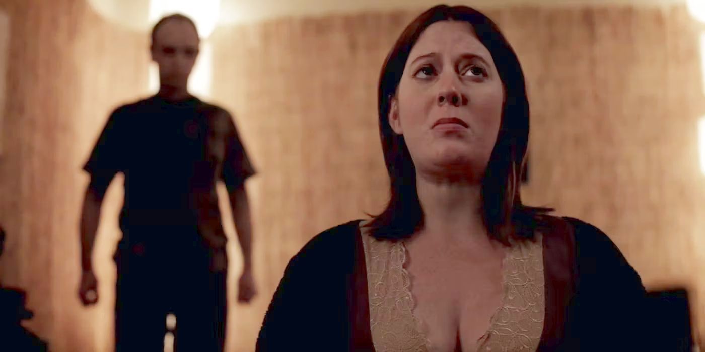 Katie Parker as Callie Russel, looking upset while a man looms behind her in Absentia