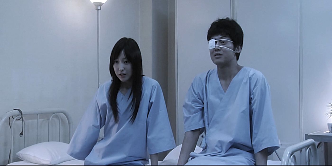 Aki e Kazuo sentados juntos em uma cama de hospital em Grotesque