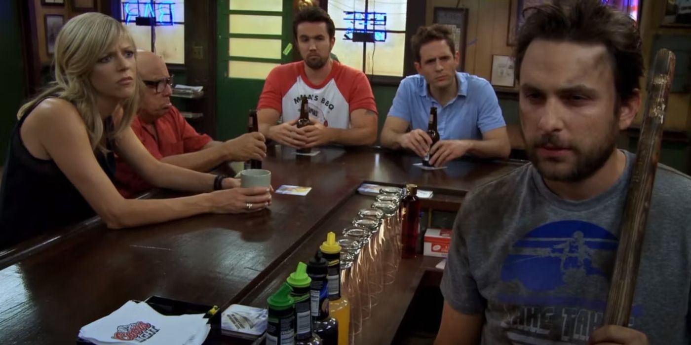 The Gang sit at the bar looking at a dirty Charlie, in Charlie Kelly: King of the Rats